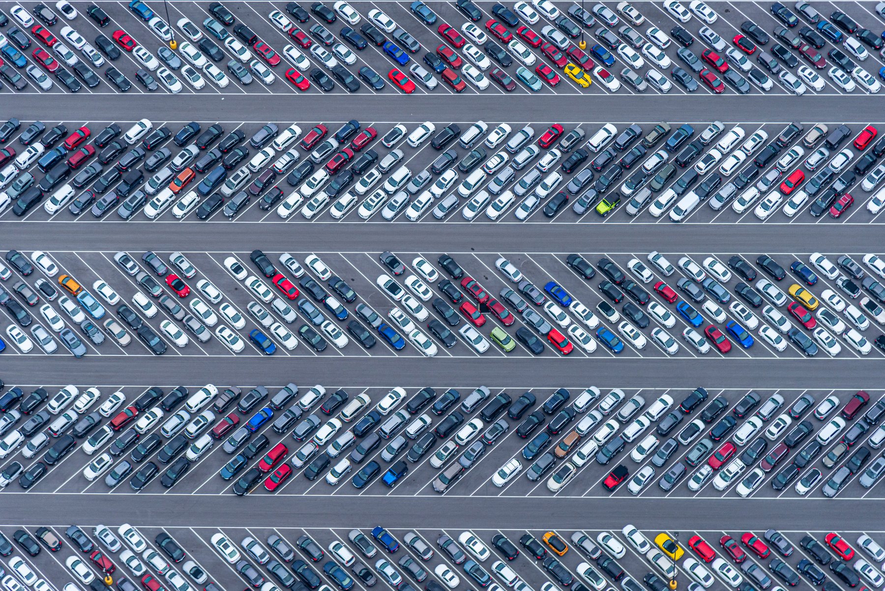 Aerial view of rows of vehicles in a dealership parking lot.